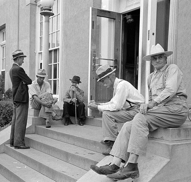 Men sitting on steps of post office, Lafayette, Louisiana    Photo: Russell Lee