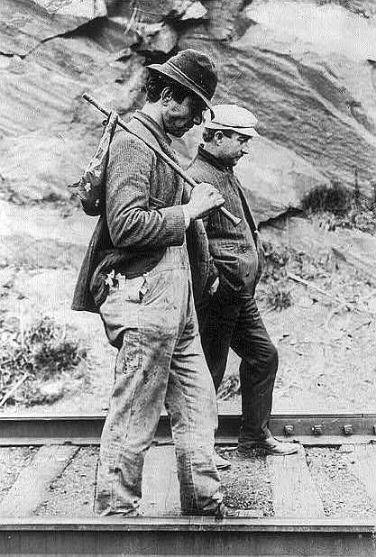 Two hobos walking along railroad tracks, after being put off a train
