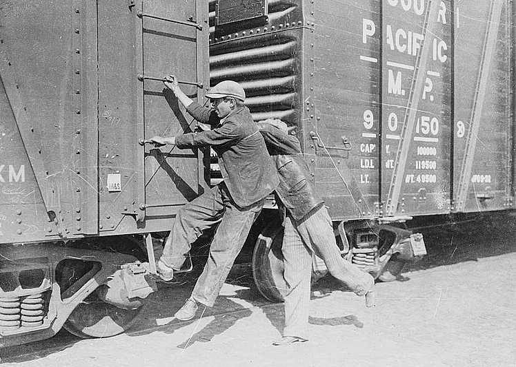 Boys hopping a freight train during the Great Depression